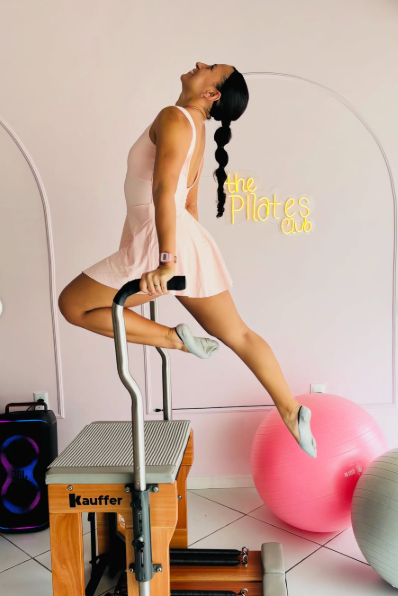 Aluna em exercício no aparelho de pilates dentro do studio The Pilates Club