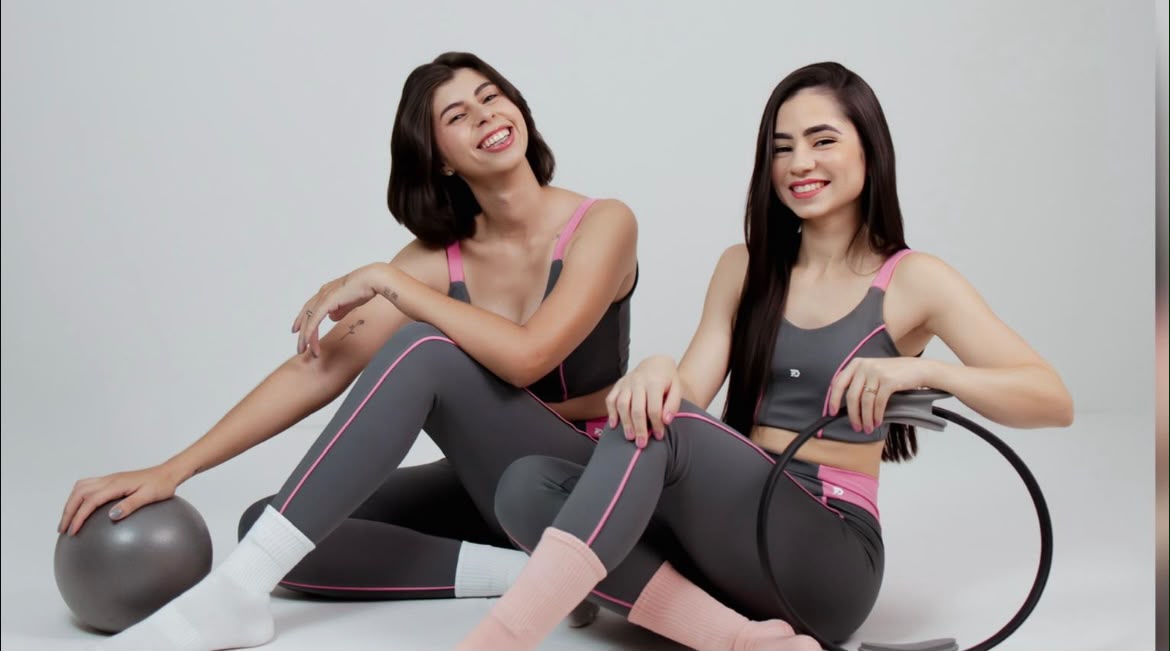 Duas alunas sorrindo após a aula, com bola e magic circle de pilates